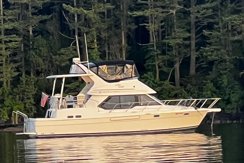 Slide: The Image of 1996 Bayliner 4087 Aft Cabin Motoryacht on calm water, surrounded by trees. - 1