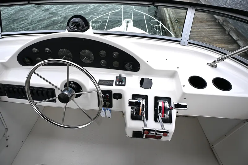 Slide: The Image of 1996 Bayliner 4087 Aft Cabin Motoryacht helm with steering wheel and control panel. - 22
