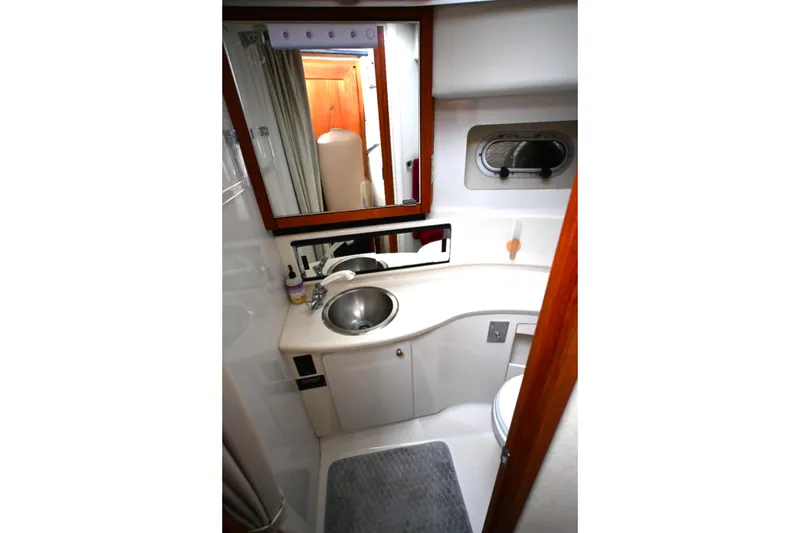 Slide: The Image of 1996 Bayliner 4087 Aft Cabin Motoryacht bathroom with sink, mirror, and porthole window. - 33