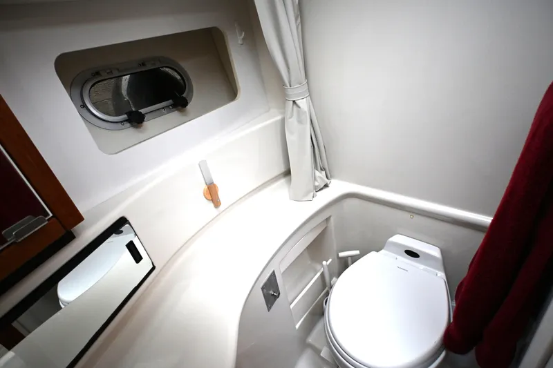 Slide: The Image of Bathroom interior of 1996 Bayliner 4087 Aft Cabin Motoryacht, featuring toilet and porthole window. - 34