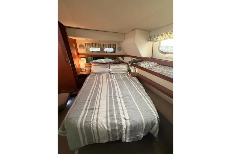 Slide: The Image of Cozy bedroom in 1996 Bayliner 4087 Aft Cabin Motoryacht with striped bedding and porthole windows. - 38
