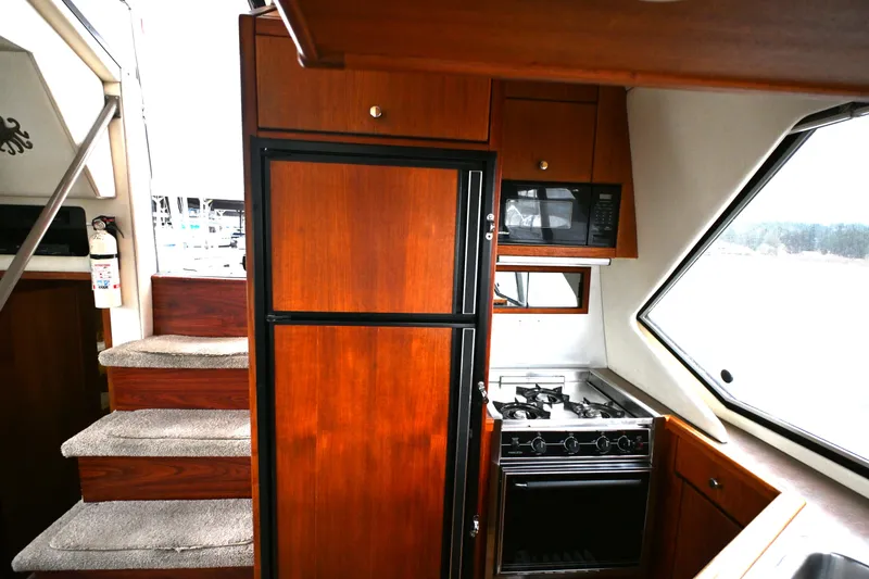 Slide: The Image of 1996 Bayliner 4087 Aft Cabin Motoryacht kitchen with wood cabinetry and modern appliances. - 46