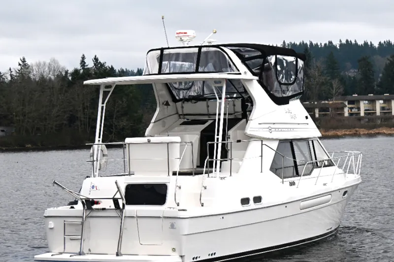Slide: The Image of 1996 Bayliner 4087 Aft Cabin Motoryacht cruising on a calm lake with forested shoreline. - 5