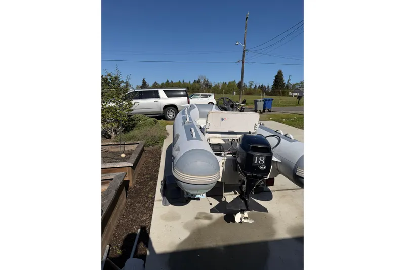 Slide: The Image of Inflatable boat with 18 HP motor, parked outdoors near a Bayliner 4087 Aft Cabin Motoryacht. - 71