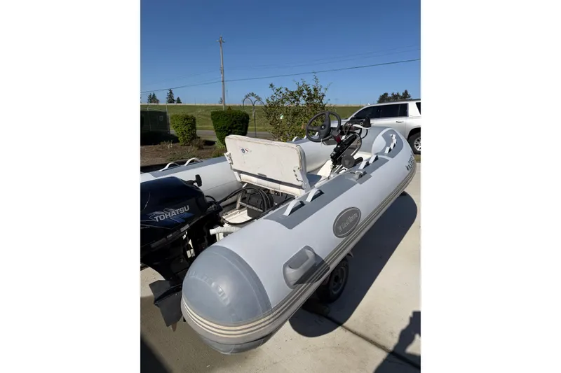 Slide: The Image of Inflatable boat with Tohatsu motor, parked outdoors, associated with 1996 Bayliner 4087 Aft Cabin Motoryacht. - 72