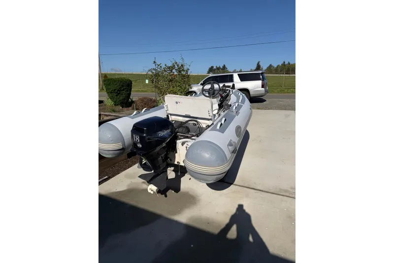 Slide: The Image of Inflatable boat with Tohatsu outboard motor, parked on concrete, sunny day. - 73