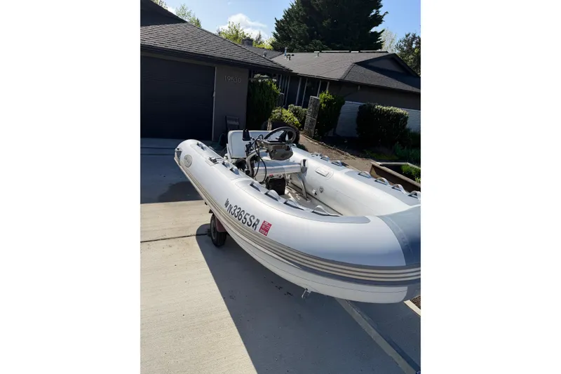 Slide: The Image of Inflatable boat on trailer in driveway, sunny day, residential background. - 74