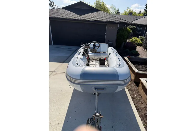 Slide: The Image of Inflatable boat on trailer in driveway, sunny day, residential background. - 75