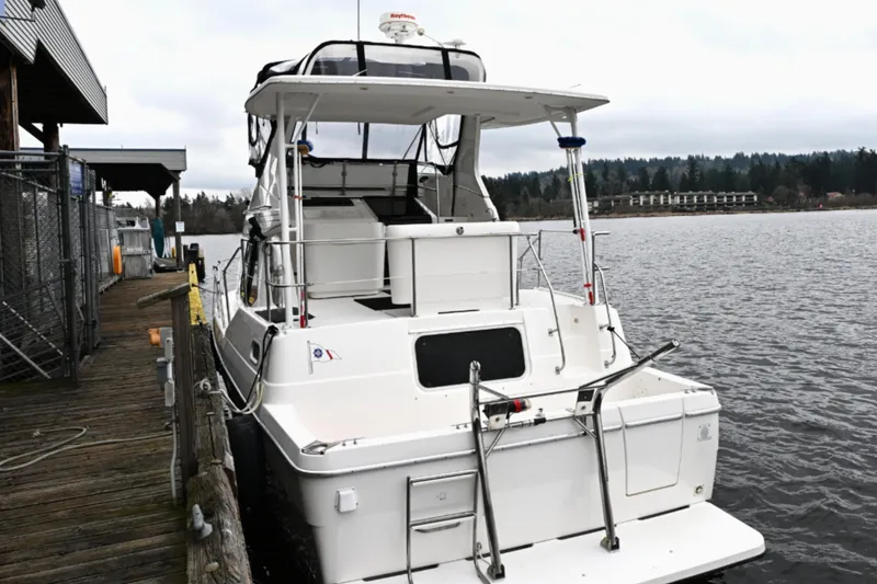 Slide: The Image of 1996 Bayliner 4087 Aft Cabin Motoryacht docked by a wooden pier on a cloudy day. - 8