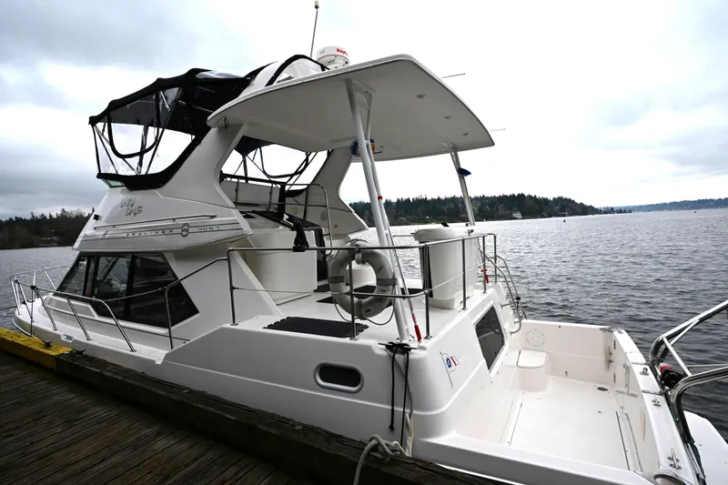Slide: The Image of 1996 Bayliner 4087 Aft Cabin Motoryacht docked by a scenic lake. - 9