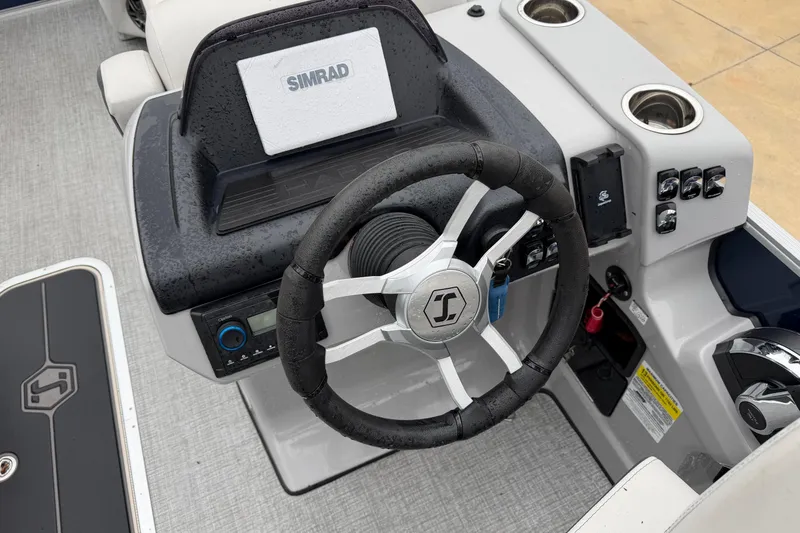 Slide: The Image of 2025 Harris Sunliner 230 boat dashboard with steering wheel and Simrad display. - 3