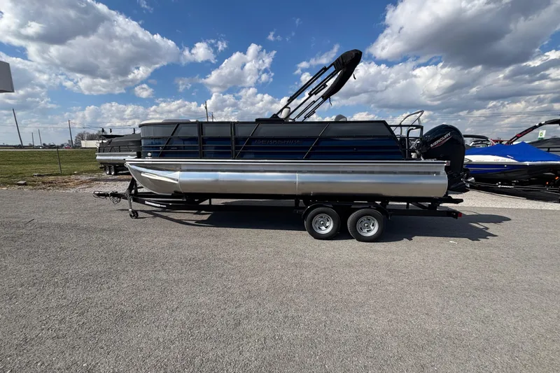 The Image of 2026 Berkshire 22UL LE B pontoon boat on trailer under a cloudy sky. - 1