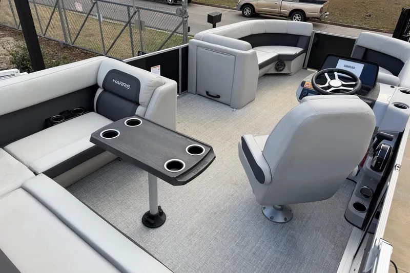 Slide: The Image of 2024 Harris Cruiser 230 pontoon boat interior with seating and steering console. - 4