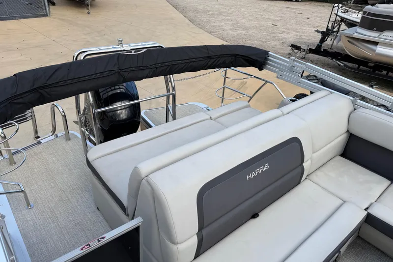 Slide: The Image of 2024 Harris Cruiser 230 pontoon boat with plush seating and sleek design. - 5