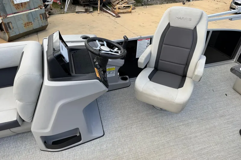 Slide: The Image of 2024 Harris Cruiser 230 boat interior with steering console and captain's chair. - 6