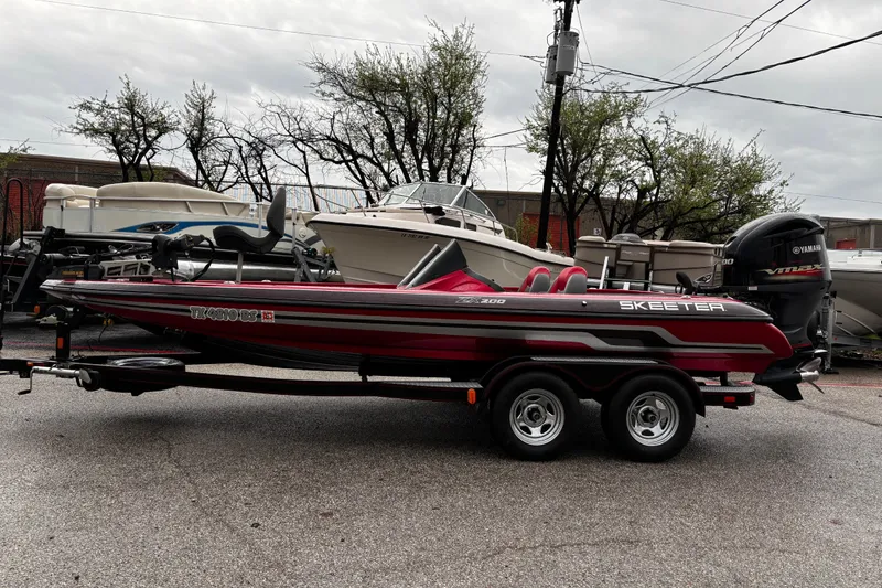 Slide: The Image of 2012 Skeeter ZX200 boat with red and black seats, wet from rain, under cloudy sky. - 41