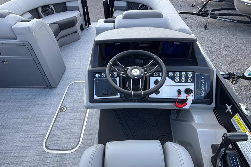 Slide: The Image of 2026 Berkshire 23RFX STS boat interior with steering wheel and seating area. - 11