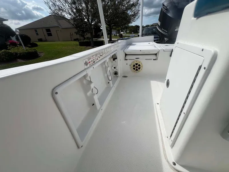 Slide: The Image of 2014 Sea Hunt SXS boat interior with storage compartments and speaker, outdoor setting. - 9