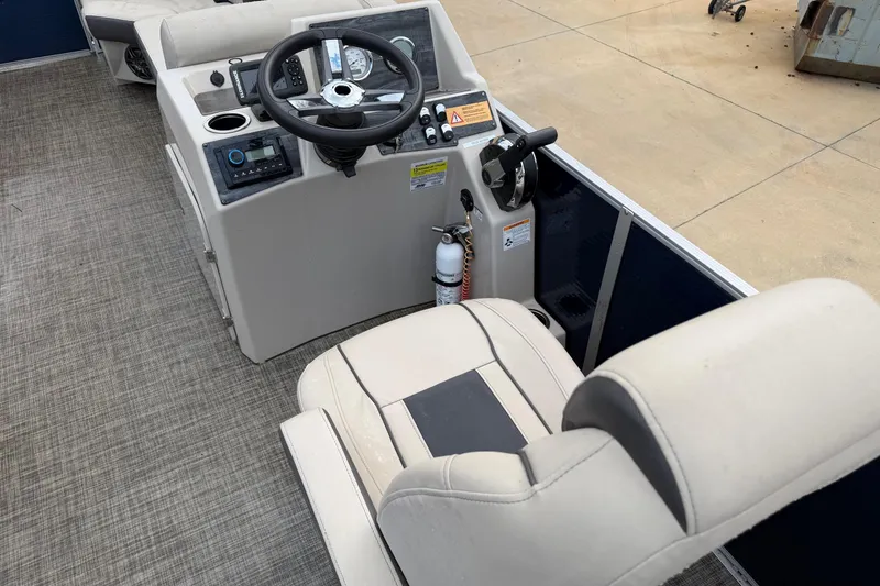 Slide: The Image of 2023 Harris Cruiser 230 boat interior with steering console and captain's chair. - 5