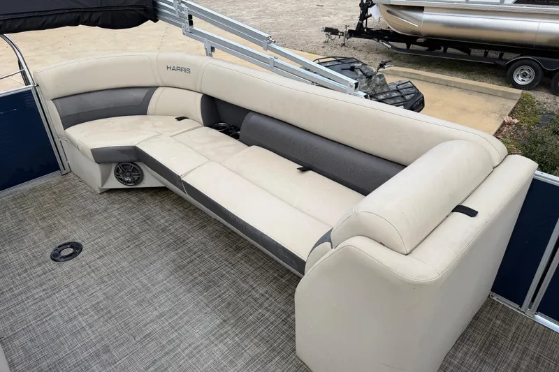 Slide: The Image of 2023 Harris Cruiser 230 boat interior with beige seating and gray accents. - 6