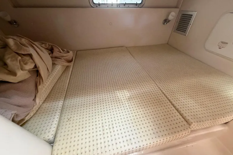 Slide: The Image of 2003 Wellcraft 270 Coastal O/B cabin interior with bed and window. - 13