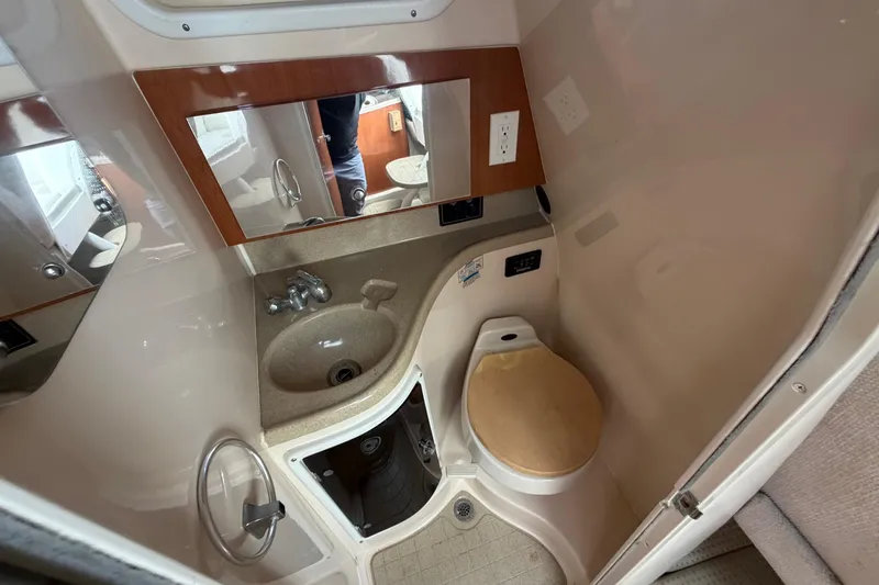 Slide: The Image of Compact bathroom in 2003 Wellcraft 270 Coastal O/B boat, featuring sink and toilet. - 14