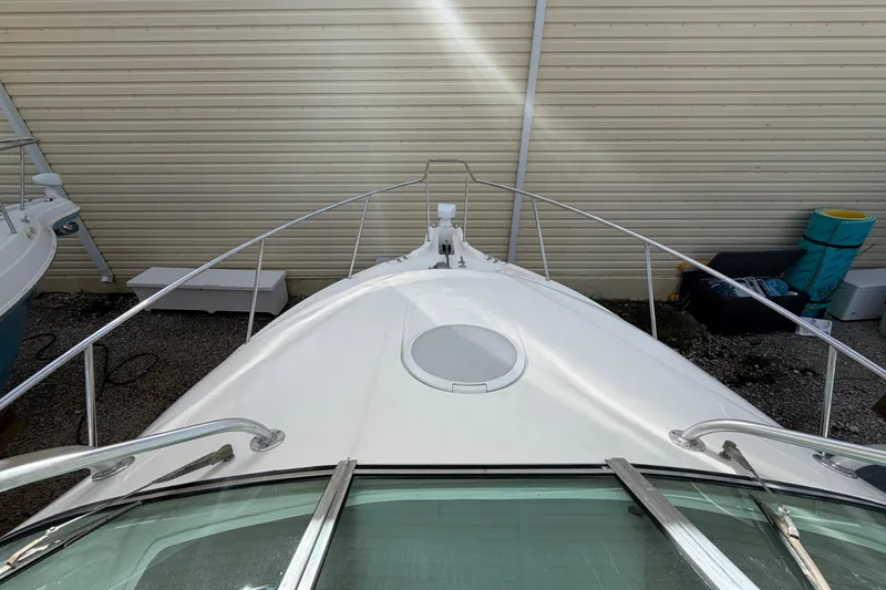 Slide: The Image of 2003 Wellcraft 270 Coastal O/B boat bow view, docked near a beige wall. - 15