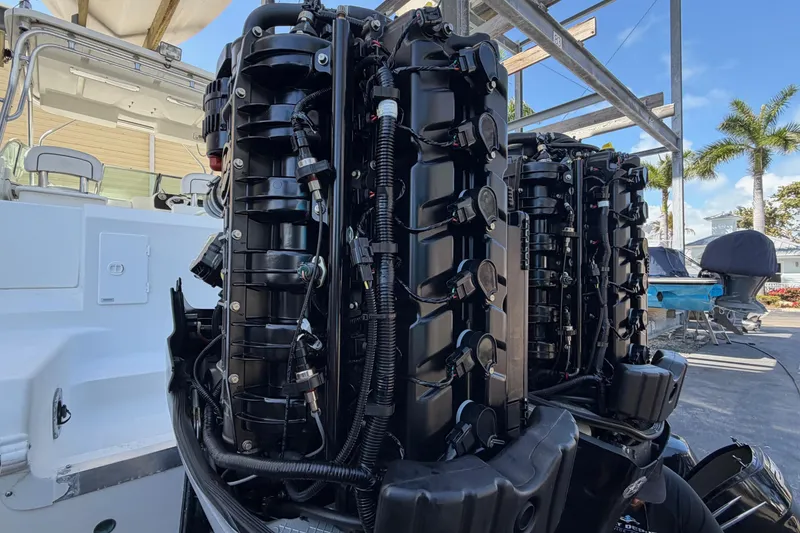 Slide: The Image of 2003 Wellcraft 270 Coastal O/B boat with dual outboard engines, docked under a clear sky. - 19