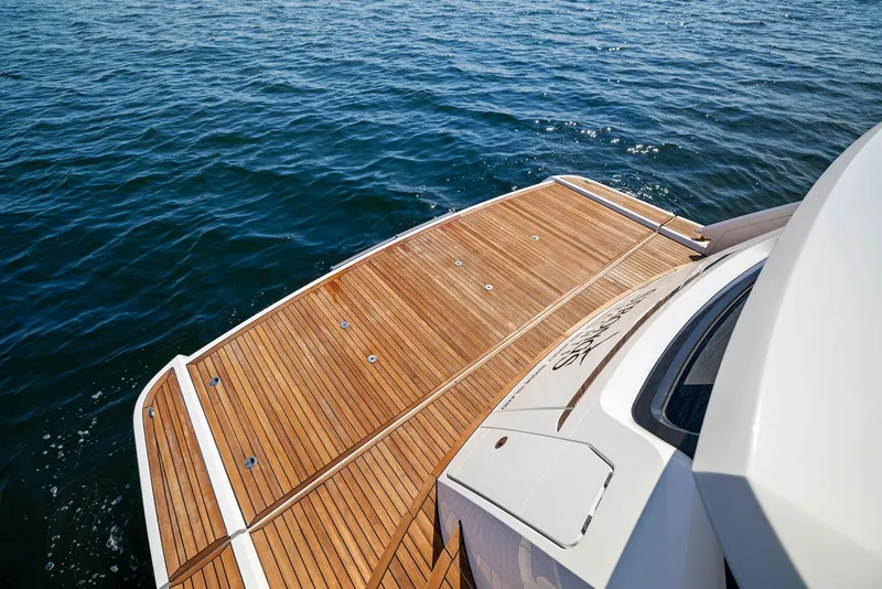 Slide: The Image of Fairline 2024 Squadron 68 yacht with teak deck on calm ocean water. - 10
