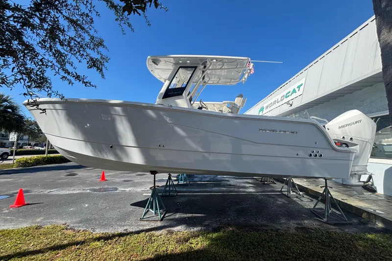 The Image of 2026 World Cat 265 CC-X boat displayed outdoors on stands, clear blue sky background. - 0