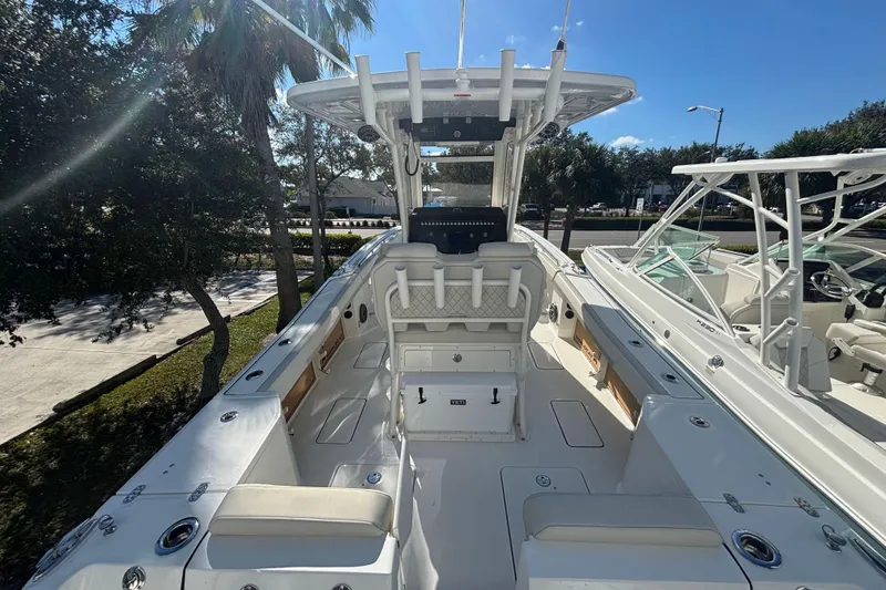 Slide: The Image of 2026 World Cat 265 CC-X boat interior with seating and console, under clear blue sky. - 10