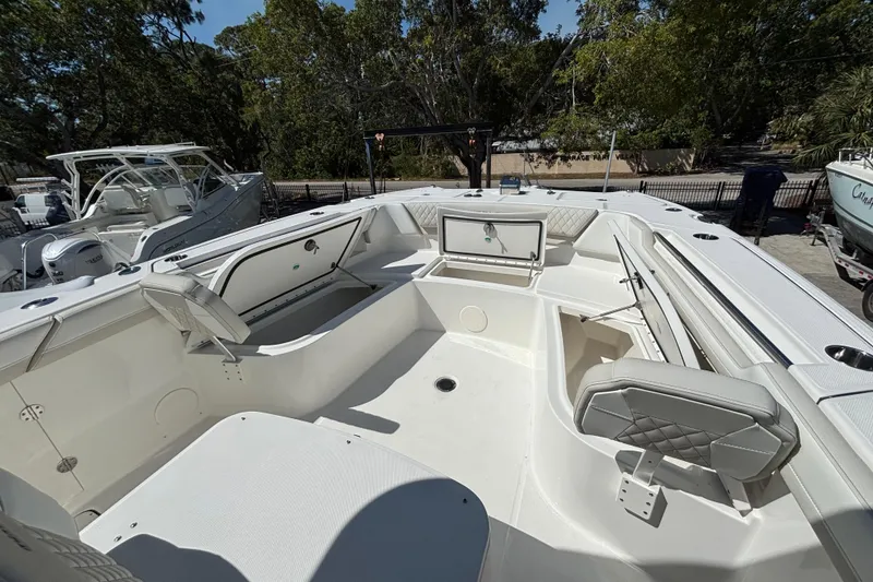 Slide: The Image of 2025 World Cat 325 CC boat interior with seating and storage, docked outdoors. - 13