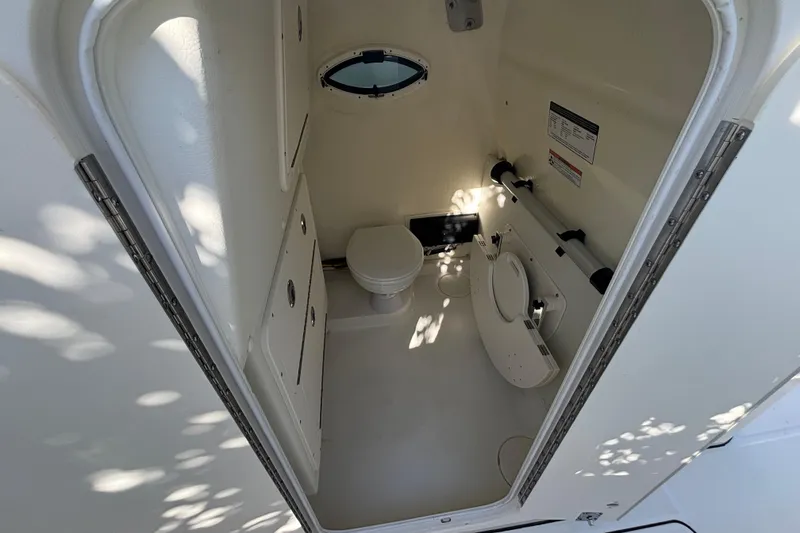 Slide: The Image of Interior of 2025 World Cat 325 CC boat bathroom with compact design and porthole window. - 5
