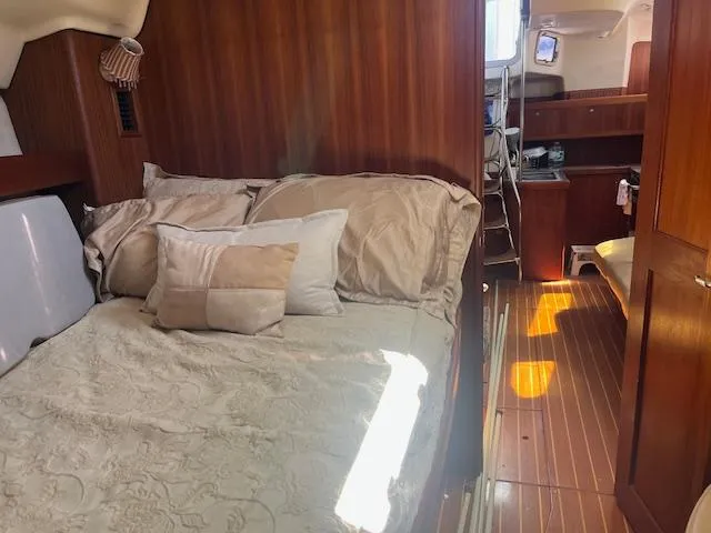Slide: The Image of Cozy cabin interior of 1999 Hunter Passage 450 sailboat with bed and wooden furnishings. - 6