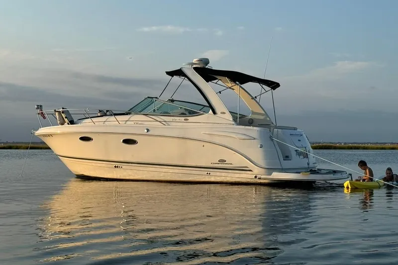 The Image of 2006 Chaparral Signature 310 boat anchored on calm water at sunset. - 0
