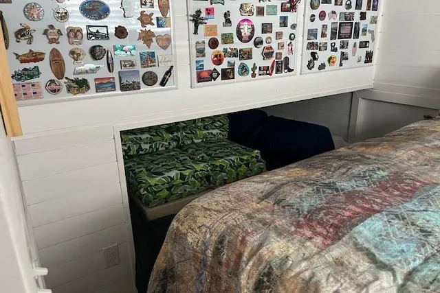 Slide: The Image of Cozy Harbor Cottage interior with bed, vibrant bedding, and wall adorned with colorful magnets. - 13