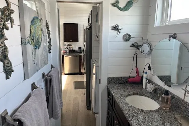 Slide: The Image of Modern bathroom in 2021 Harbor Cottage, featuring granite countertop and nautical decor. - 16