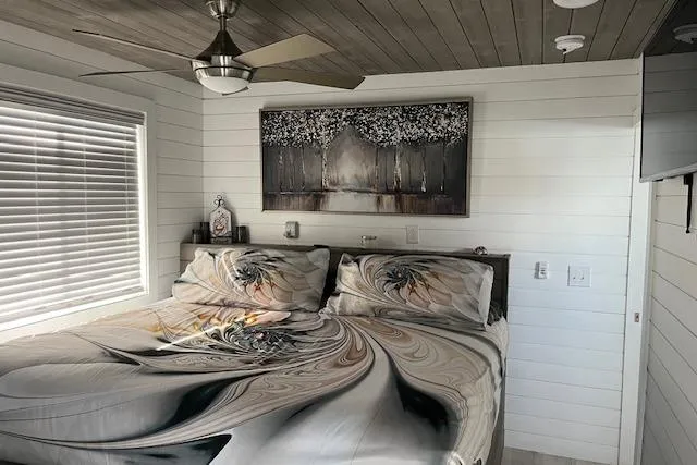 Slide: The Image of Cozy Harbor Cottage bedroom with abstract bedding, modern ceiling fan, and serene wall art. - 18