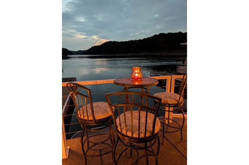 Slide: The Image of Cozy lakeside patio with candlelit table and chairs at sunset, Harbor Cottage 2021 model. - 36