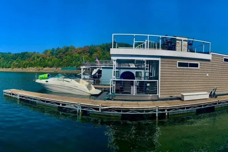 Slide: The Image of Houseboat by Harbor Cottage, 2021 model, docked with a speedboat on a serene lake. - 41
