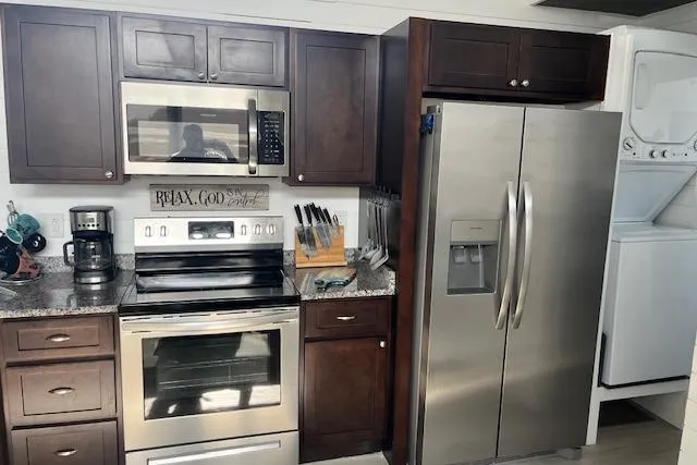 Slide: The Image of Modern kitchen in 2021 Harbor Cottage, featuring stainless steel appliances and dark wood cabinets. - 8