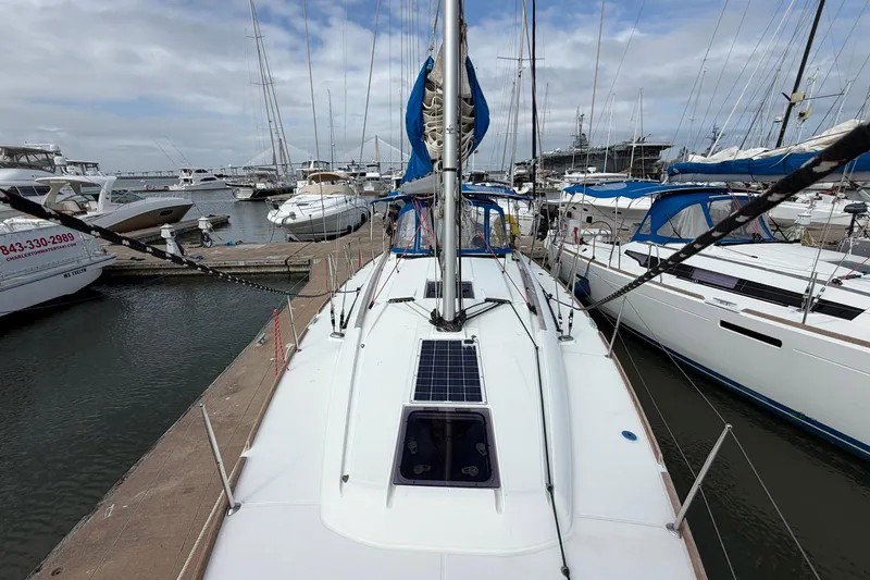Slide: The Image of 2018 Jeanneau Sun Odyssey 389 sailboat docked at a marina, surrounded by other boats. - 12