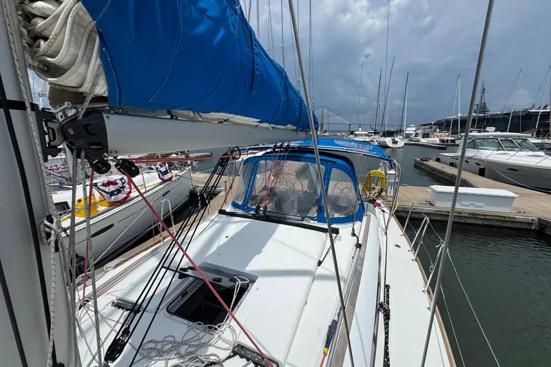 Slide: The Image of 2018 Jeanneau Sun Odyssey 389 sailboat docked at marina, featuring blue sail cover. - 13