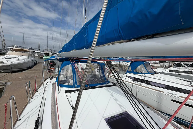 Slide: The Image of 2018 Jeanneau Sun Odyssey 389 sailboat docked at marina, featuring blue sail cover. - 15