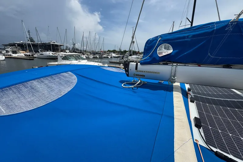 Slide: The Image of 2018 Jeanneau Sun Odyssey 389 sailboat with blue cover docked at marina. - 16