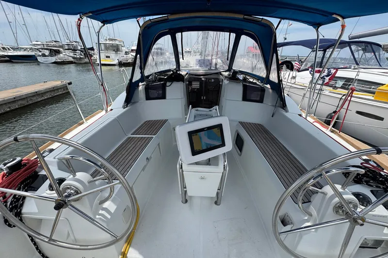 Slide: The Image of 2018 Jeanneau Sun Odyssey 389 sailboat cockpit with dual steering wheels and navigation display. - 19