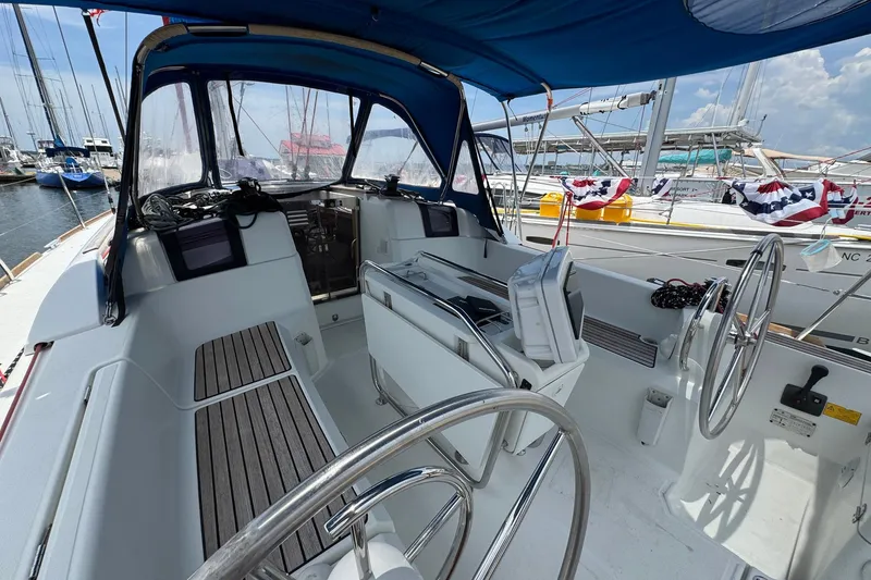Slide: The Image of Cockpit of 2018 Jeanneau Sun Odyssey 389 sailboat, featuring dual steering wheels and navigation equipment. - 21