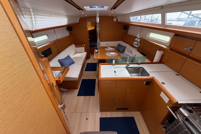 Slide: The Image of 2018 Jeanneau Sun Odyssey 389 interior with modern kitchen and cozy seating area. - 28