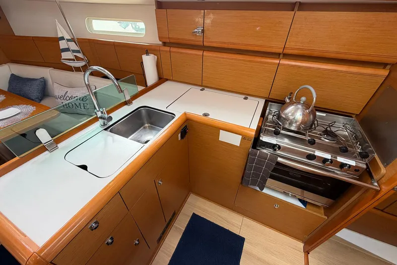 Slide: The Image of Modern kitchen in 2018 Jeanneau Sun Odyssey 389 yacht with stove, sink, and wooden cabinetry. - 32