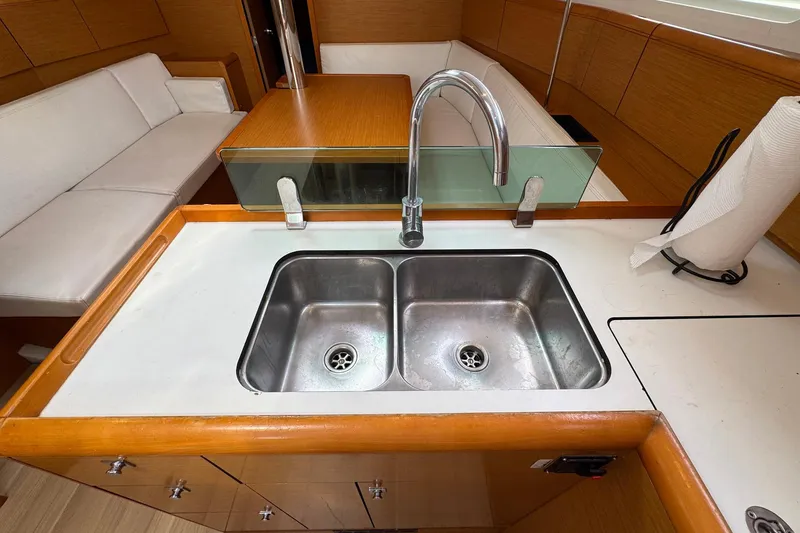 Slide: The Image of Jeanneau Sun Odyssey 389 yacht interior, featuring a modern kitchen sink and seating area, 2018 model. - 33